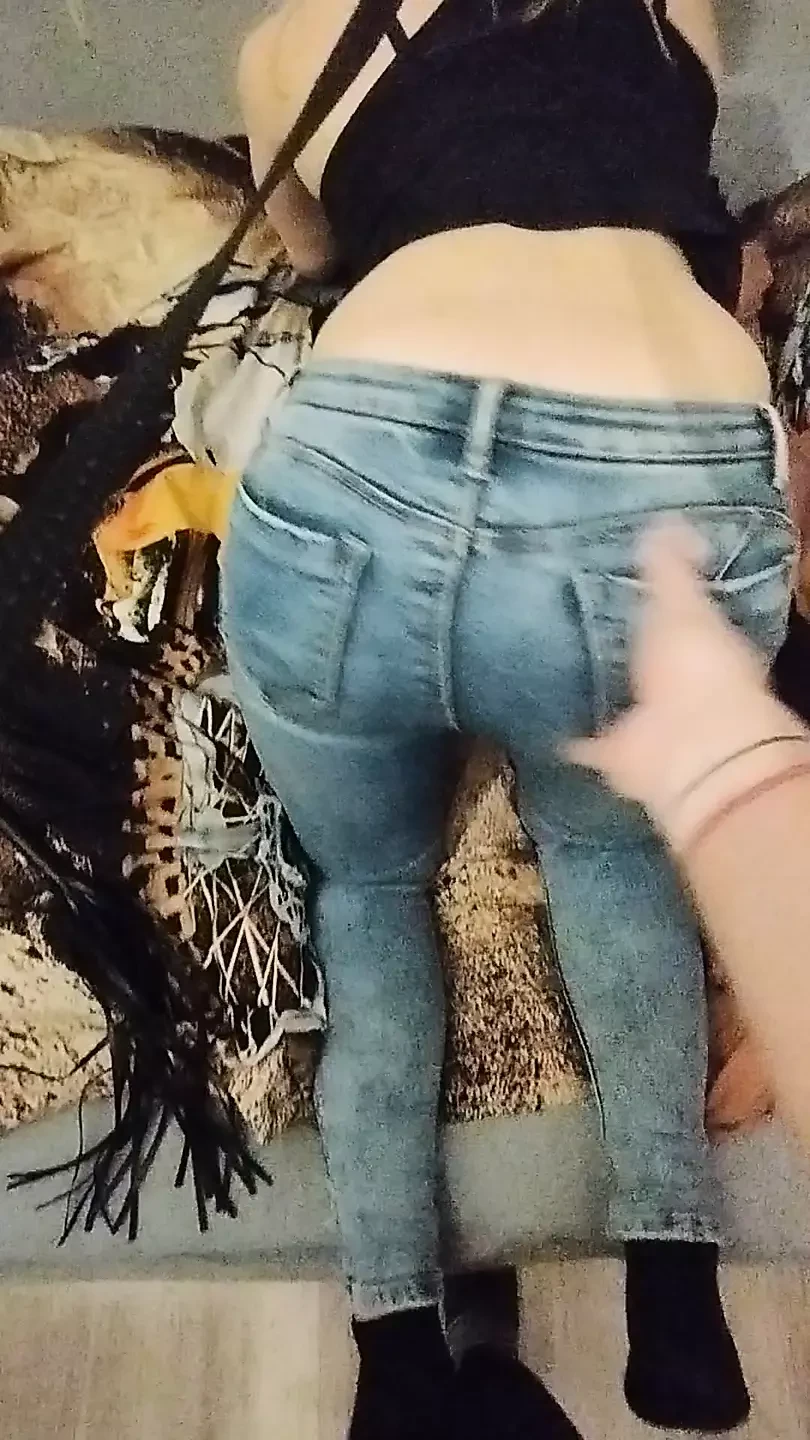 穿着牛仔裤的女孩挑逗和摩擦阴户的屁股