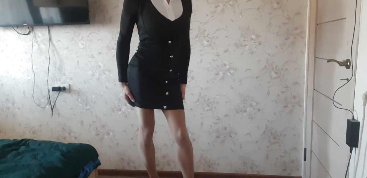 in a business suit, with a pink bodysuit underneath