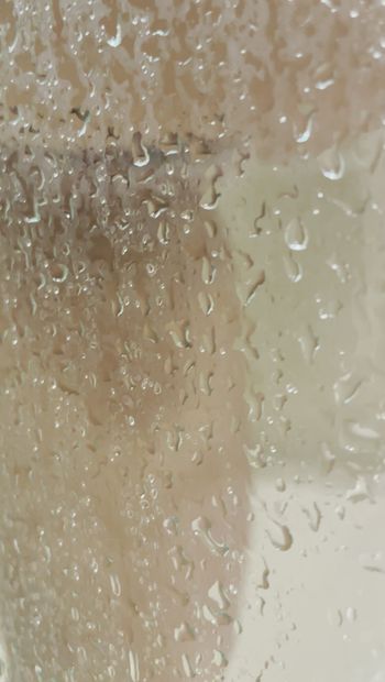 Tetas mojadas en una ventana de ducha sudorosa
