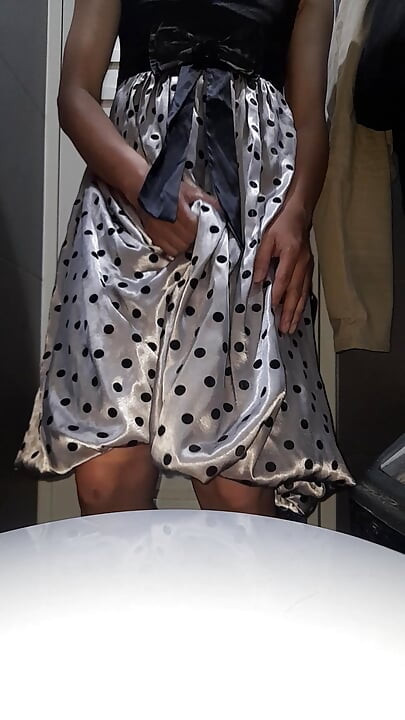 Crossdresser nosi satensku svilenu haljinu na točkice sa svilenkastom podstavom