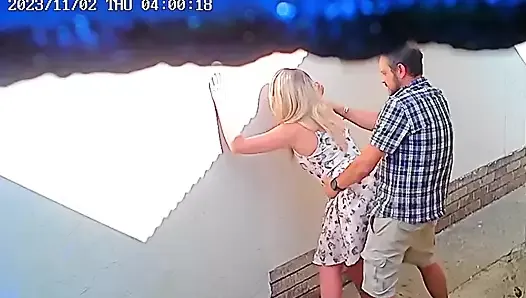 Des images de voyeur d’un couple en train de baiser devant un entrepôt