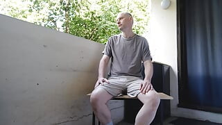 Man undressing outside on the balcony wanks his soft hair cock becoming erect as his strips