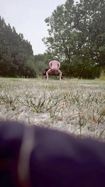 Naked in park standing on benches naked vehicles pass close
