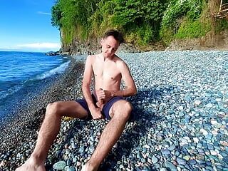 Guy jerking off dick on a nudist beach and a passerby joined him