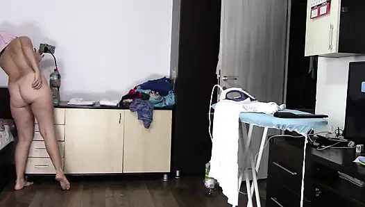 Amatör evli kadın evde çıplak dans yapıyor. Amatör kadın kıyafetlerini denerken ve keserken eğleniyor.