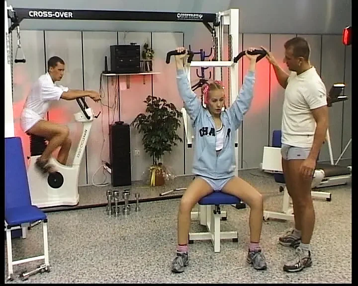 Petite blonde German babe rides two dicks in the gym