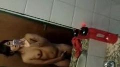 Fată auto-filmată futându-se cu degetul în baie