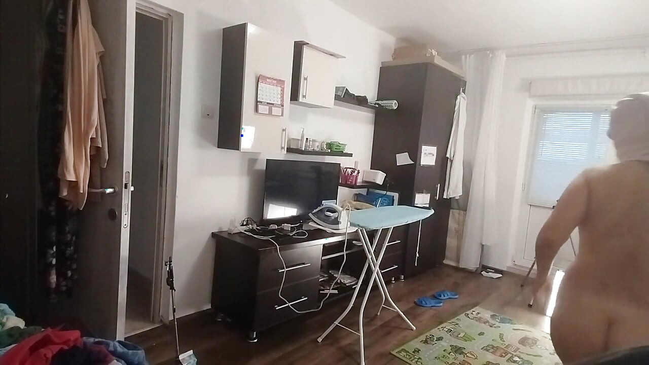 性感的黑发女郎在房子里做裸体家务