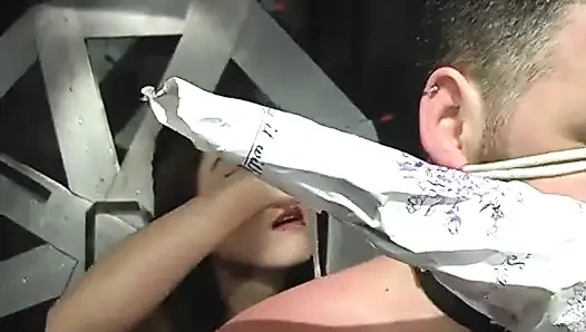 BDSM-herrin in schenkelhohen seilt das gesicht des typen mit halsband und zieht seinen gefesselten schwanz