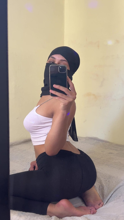 Dewi Arab yang bertudung duduk di atas katil mengusik peminat sambil memancut ke belakangnya dan menunjuk-nunjukkan pantatnya