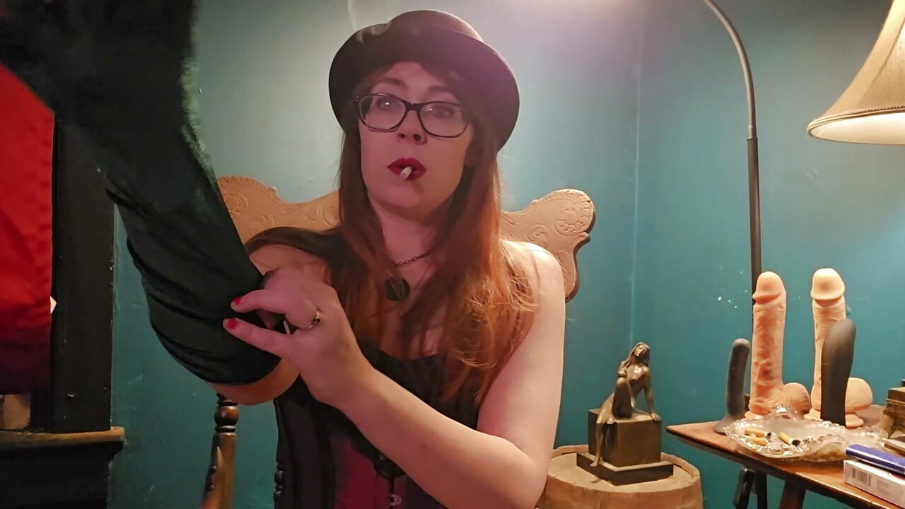 Smoking while wearing a purple corset, gloves, and a hat