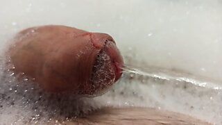 Primo piano cazzo piscia nella schiuma nella vasca da bagno