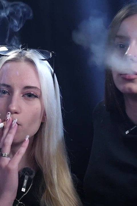 Two Women Smoking Together in a Dark Studio with Soft Blue Lighting