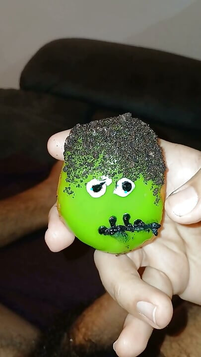 Enjoying a Donut with Haloween Decoration.