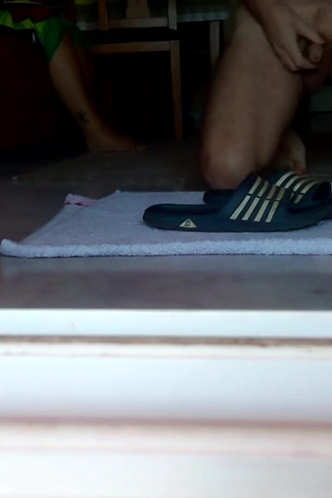 John is peeing on the bathing slippers on the floor