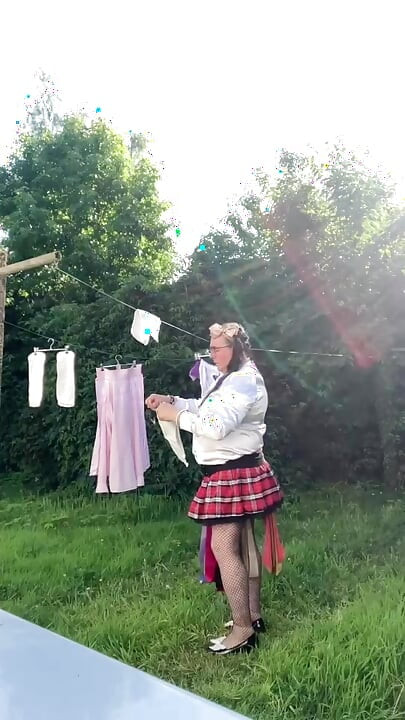 In schoolgirl outfit to hang the laundry
