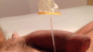 Cumming usando mala carga del condón como lubricante