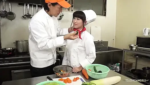 Der Koch und die Restaurantleitung tadeln den asiatischen Koch, indem sie sie anwies sie, dickes gemüse zu drücken