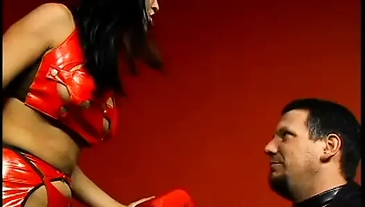 Latex-clad hottie torments a hairy guy with tats