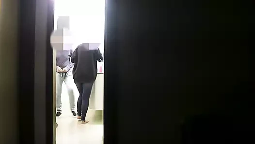 She gives a blowjob to her friend while her husband watches a series on TV.