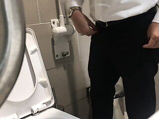トイレでおしっこをするかわいいオフィスマンを覗き見、おしっこ後にペニスが激しく大きくなるのを見る