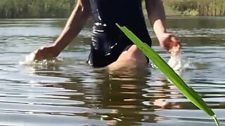 Trans djevojka pliva u jezeru u plavoj sportskoj haljini. Wetllok trans djevojka mokra.