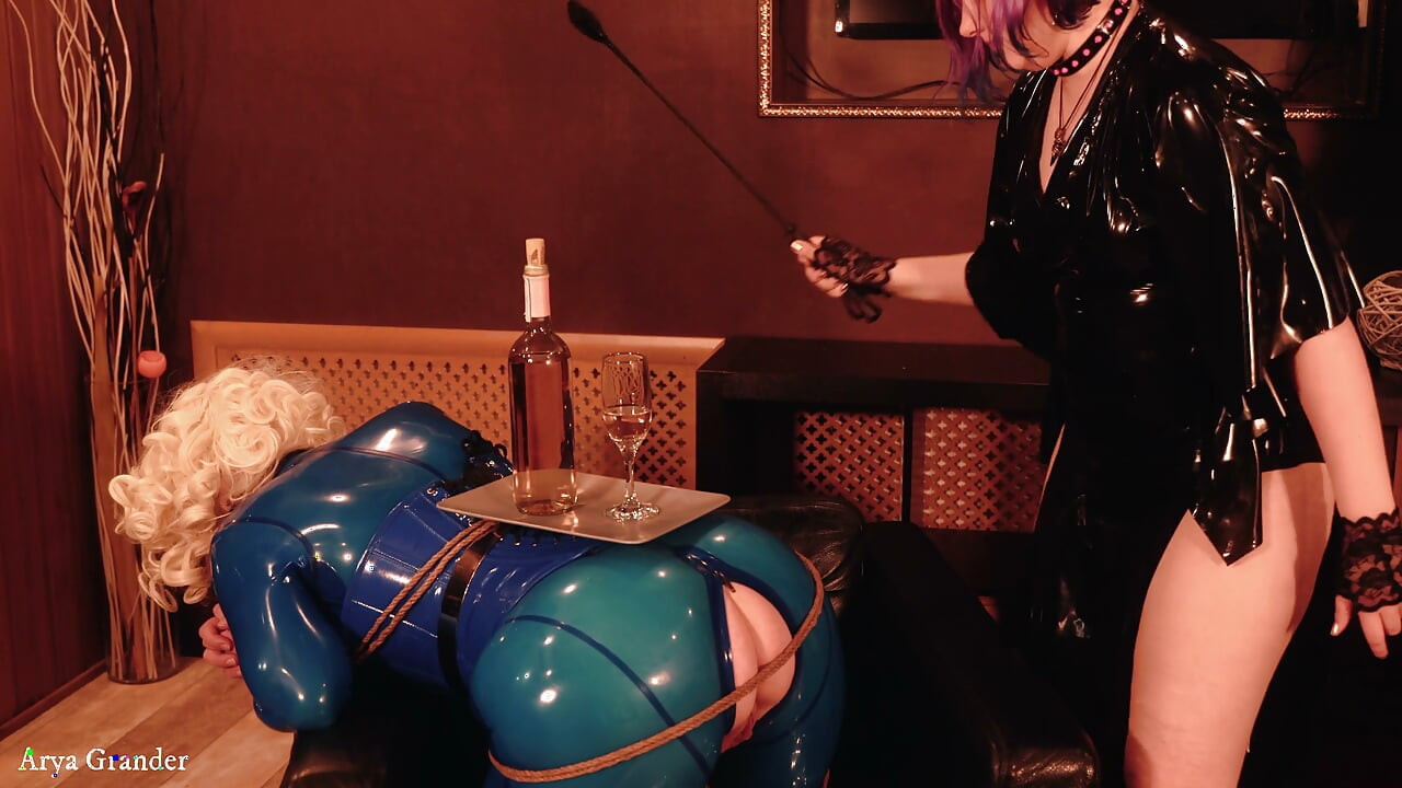Bondage process: latex mistress and rubber submissive with gag and wet pussy
