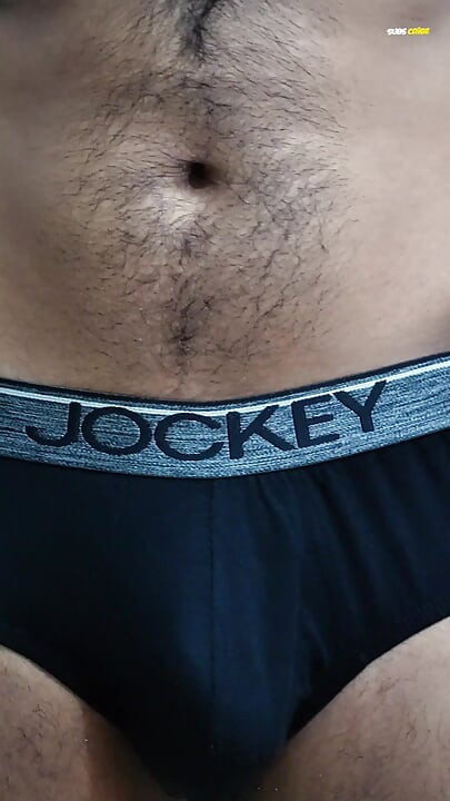 Young man wearing black underwear is dancing cock while holding his groin area.