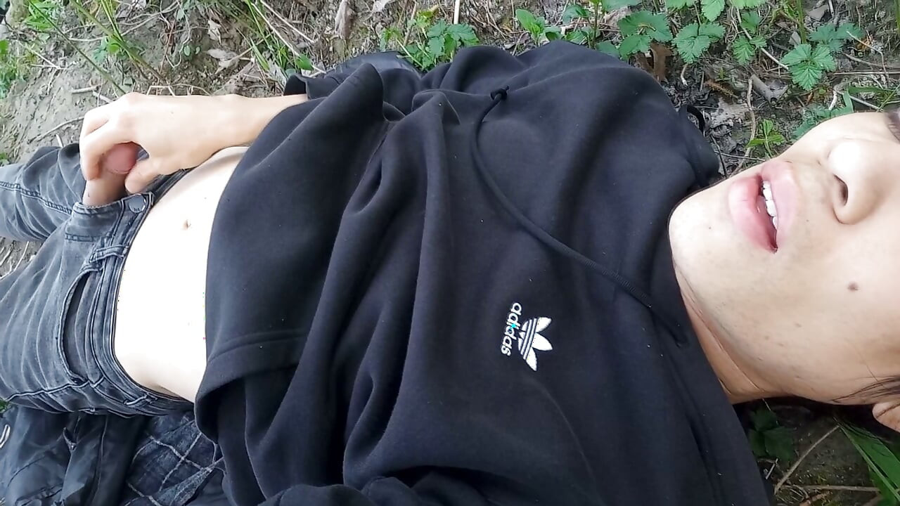 The cute gay twink jerking off his cock, pulled through his fly while outdoors, is Jon Arteen