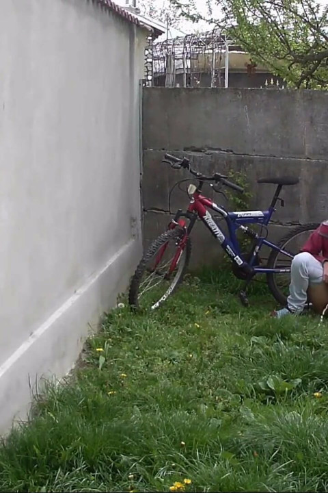 Elle pisse dans l'arrière-cour par une journée froide et part sur son vélo