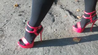 女士我穿着性感的红色高跟鞋走路。