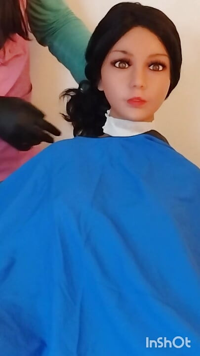 Lindsey memodelkan jubah gunting rambut dengan boneka seks berbadan besar