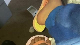 Pieds en ébène dans des tongs colorées