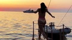 Alessandra Ambrosio jumping into the water at sunset