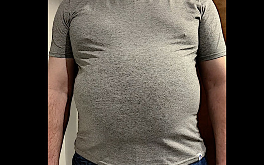 Grande barriga de trabalhador da construção civil em camisa apertada