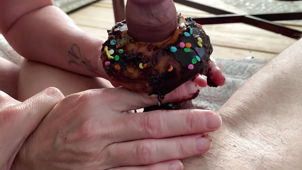 Comendo preto chocolate Pau coberto de esperma donut &sprinkles