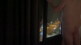 Naked standing hotel window