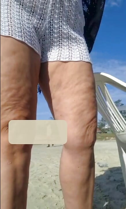 Hot crown sunbathing on the beach in transparent micro bikini
