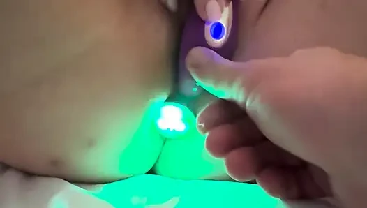 Vibrating dildo is in her pussy while lightshow butt plug is in her rectum
