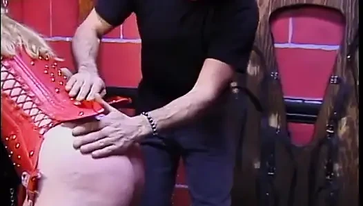 Kırmızı korseli şişman sarışın kızıl saçlının memelerini emiyor
