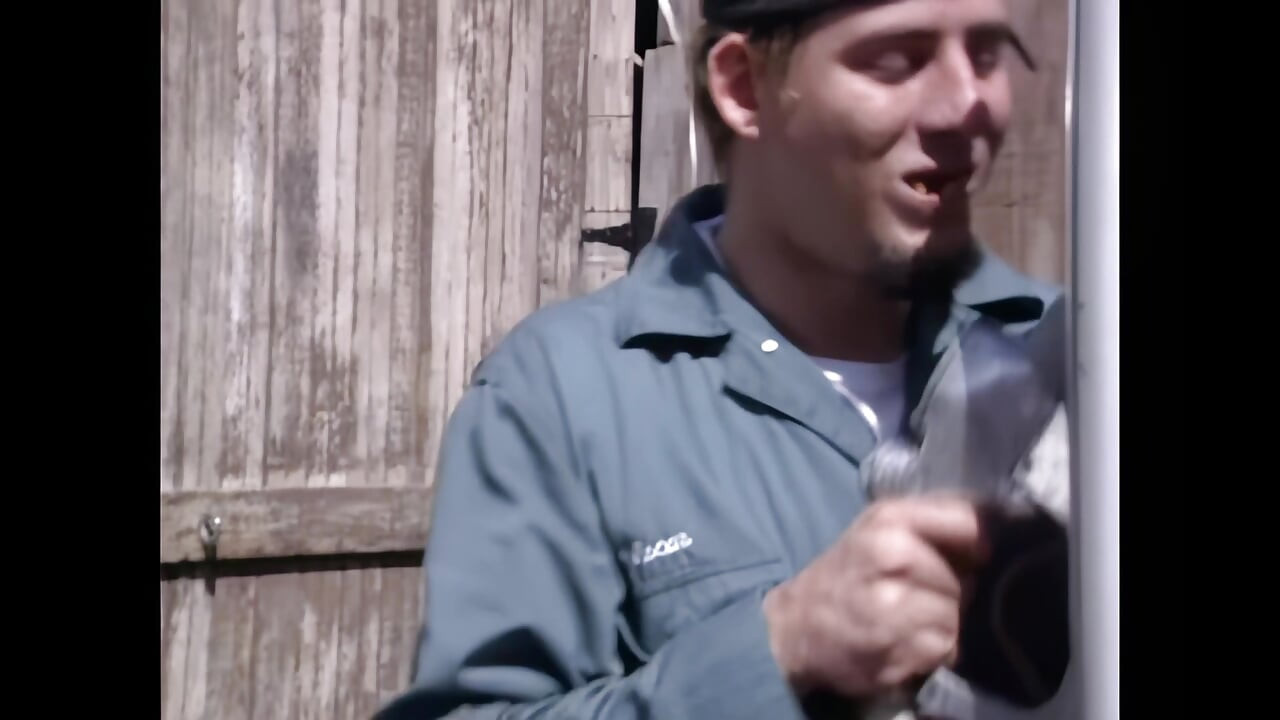 मुर्गा की सवारी के लिए उत्सुक एक युवा रेडहेड गैस स्टेशन परिचारक के बड़े मुर्गा