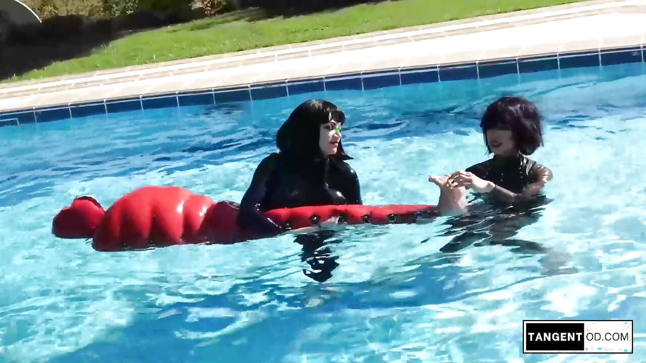 TANGENTOD Women in Black Catsuits Float Red Latex Encased Figure on Inflatable Rubber Pool Toy