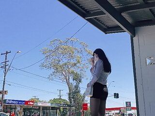 Crossdresser asiático con medias en la parada de autobús