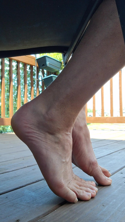 Sneak shot of my feet soles toes barefoot under a chair
