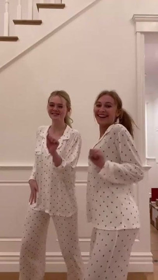 Elle Fanning and a blonde friend dancing in their pajamas