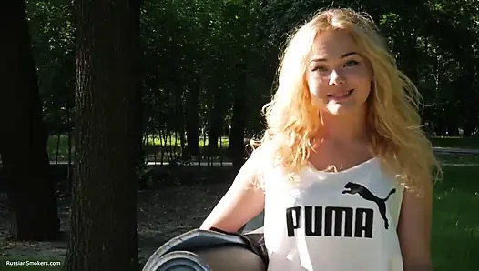 Sexy russisches mädchen, das zigarette raucht, entspannt im freien