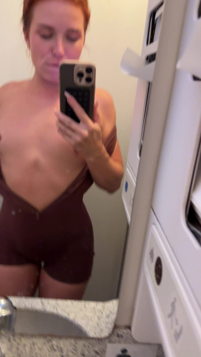 Redhead teases and flashes skin in the tight airplane bathroom stall