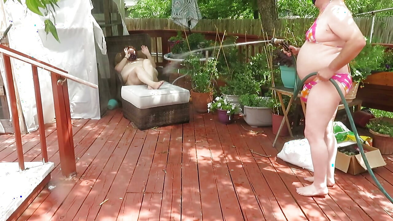 屋外でホースを使って裸で遊ぶBBWナースVickiBのループ動画