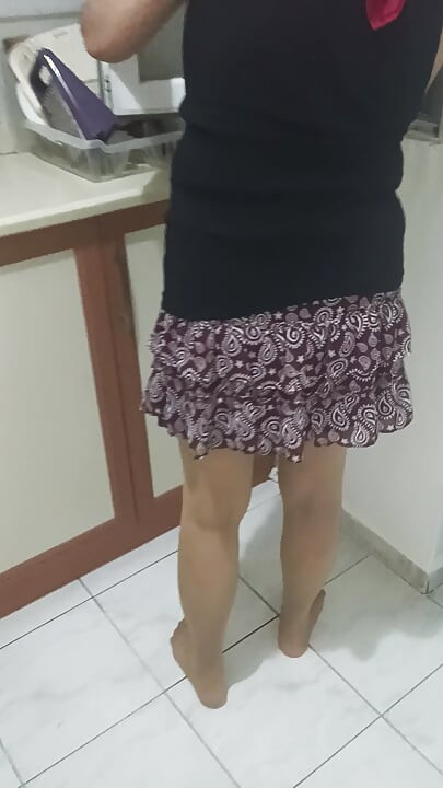 Mature woman in sheer stockings doing housework in the kitchen.