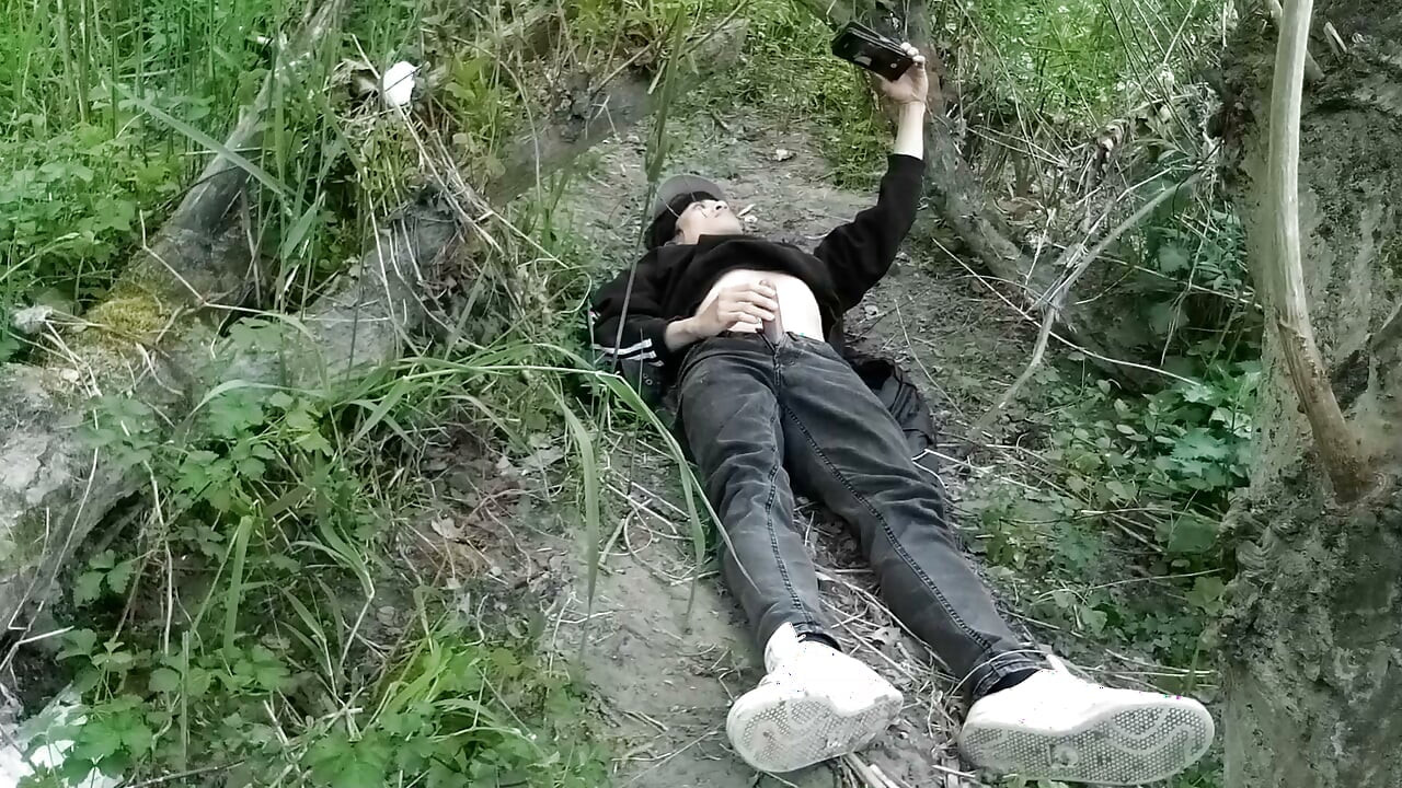 This gay twink sticks his cock through his fly to jerk off outside